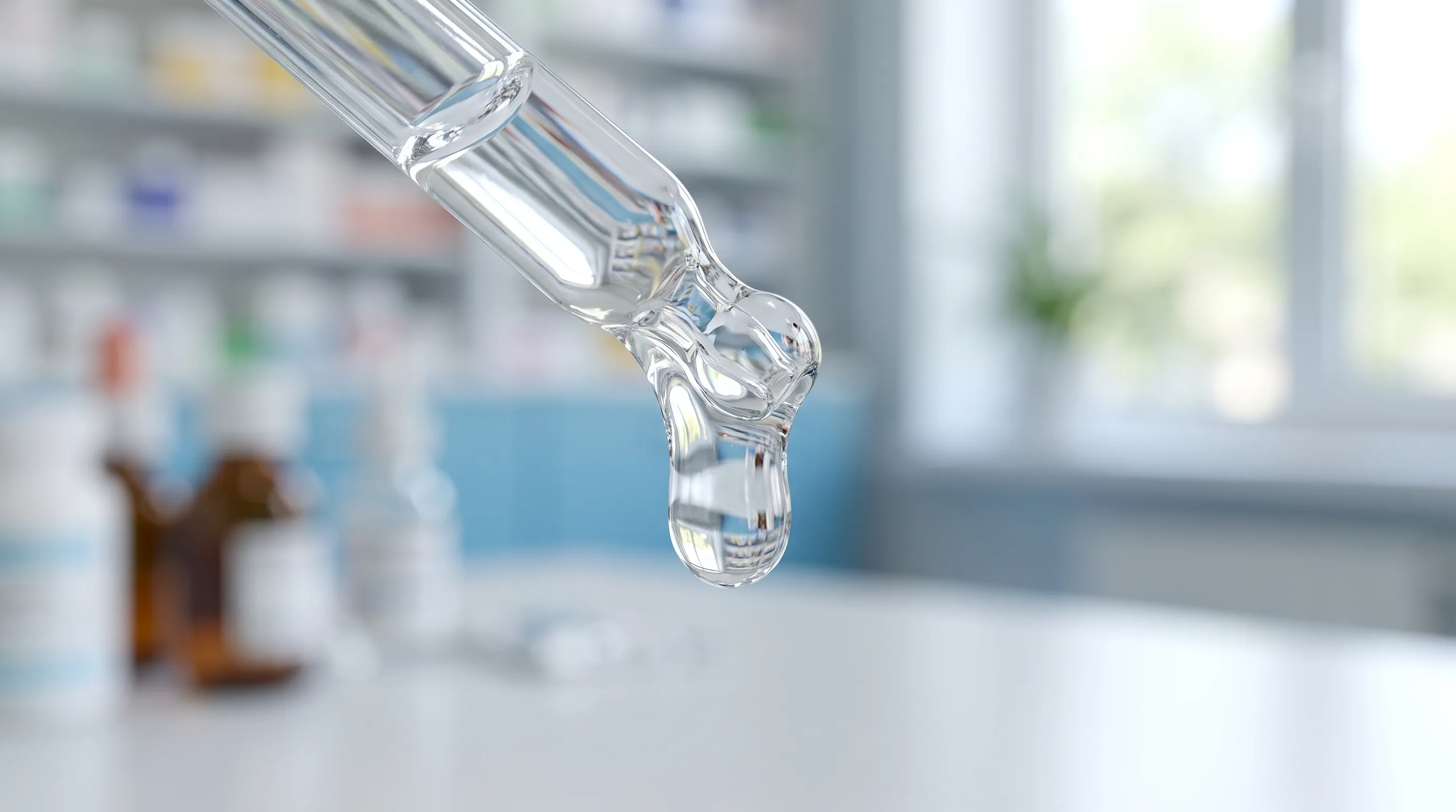 A viscous drop of hyaluronic acid on an eye dropper tip, illustrating its lubricating quality.