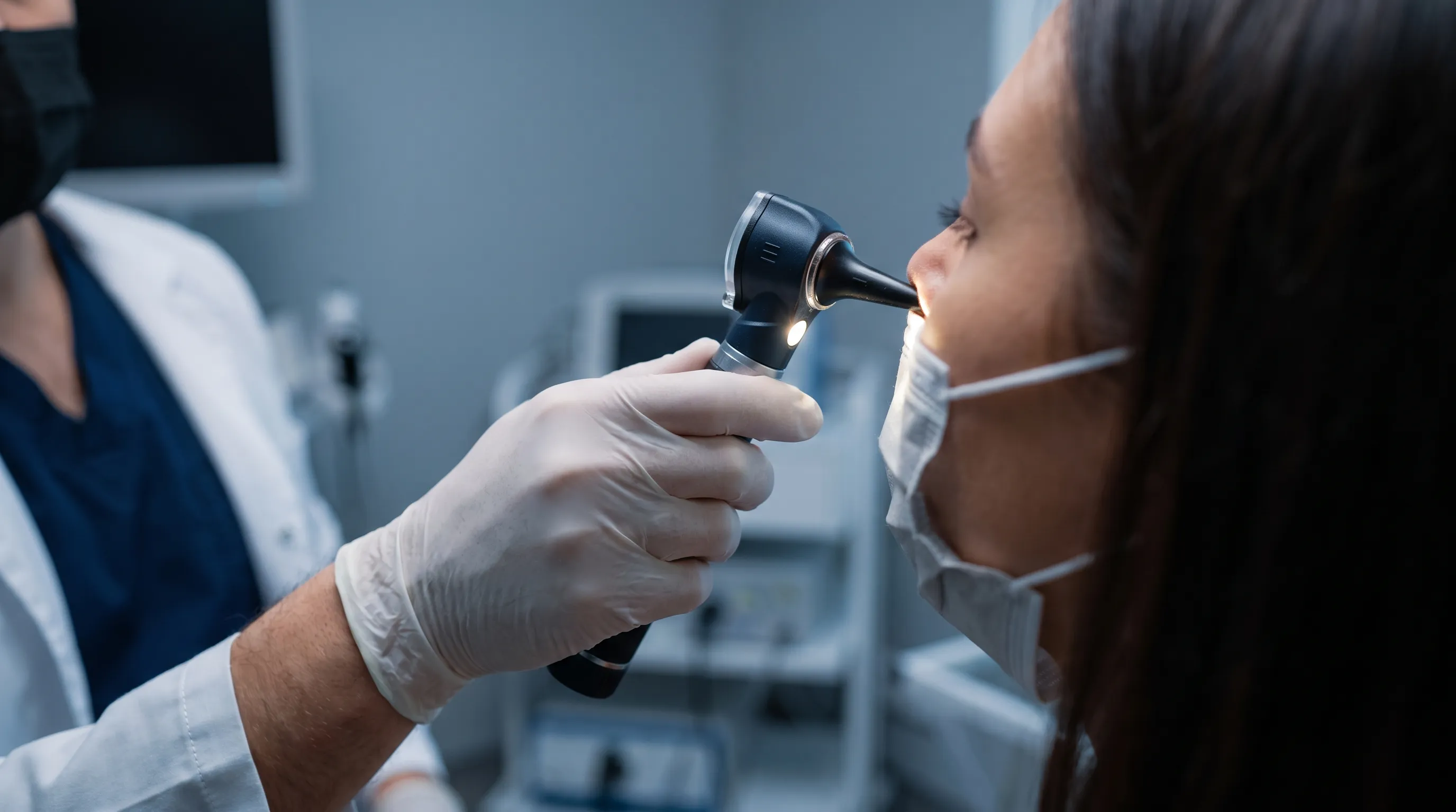 A medical professional examining a patient's nasal passages with a bright clinical light, emphasizing diagnostic precision in respiratory care