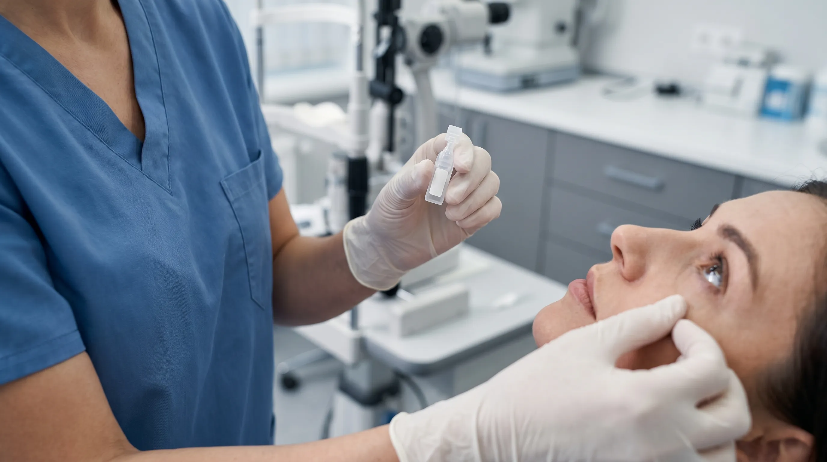 A healthcare professional demonstrating proper eye care hygiene in a modern clinical setting with soft blue and gray lighting