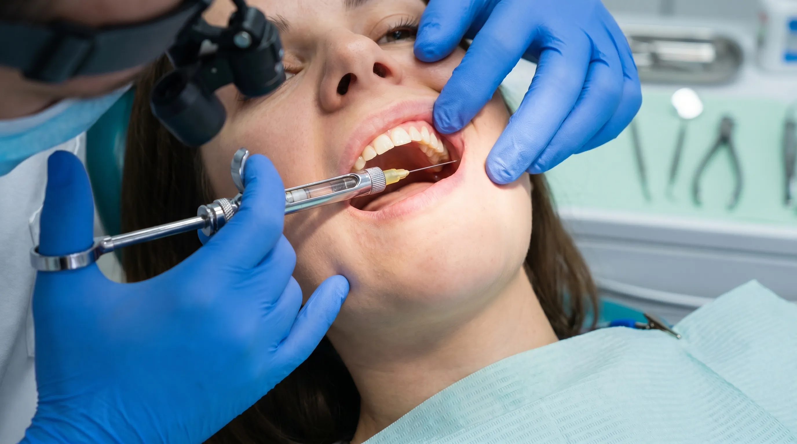 A clinical close-up of a dentist administering a local anesthetic injection to a patient's gum, showing sterile gloves, dental syringe, and professional lighting, photorealistic style